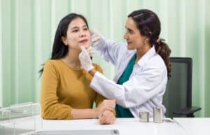Woman having her face examined by a doctor before her fat transfer procedure