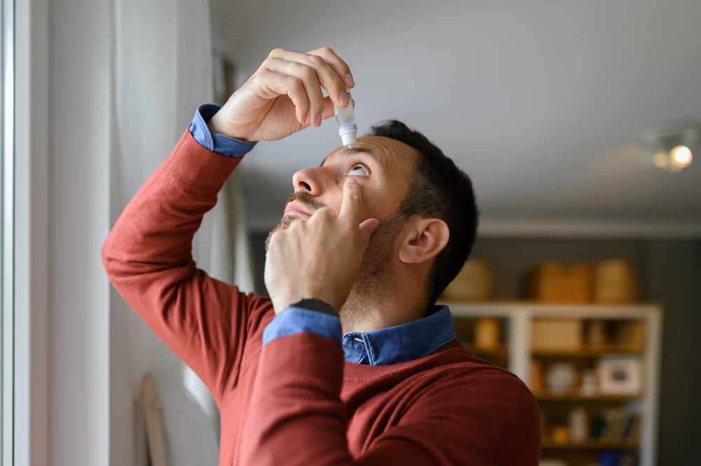 Man using eye drops for relief from eye tearing in Denver, CO
